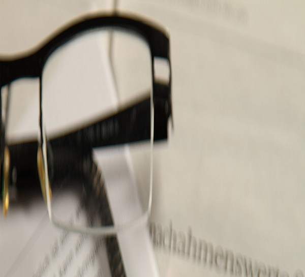 Brille auf einem Ordner mit Unterlagen - Münchener Verein